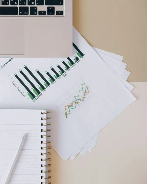 Gráficas de seguimiento impresas junto a un portátil y una libreta